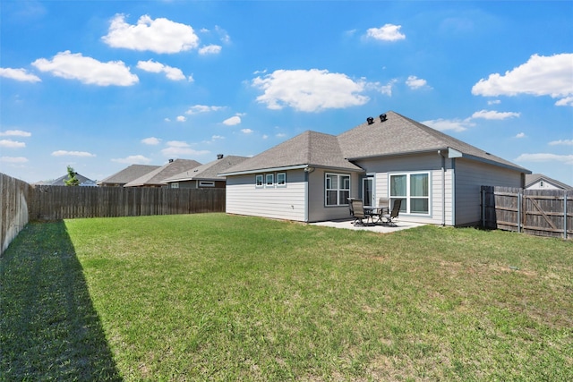 back of property with a yard, roof with shingles, a patio, and a fenced backyard