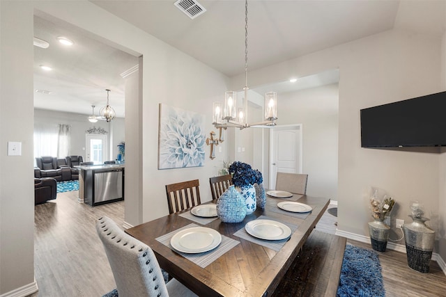 dining room featuring light wood finished floors, baseboards, visible vents, recessed lighting, and a chandelier