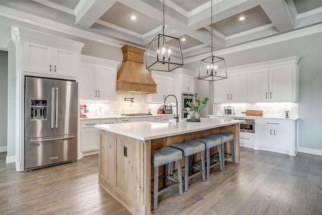 2161 Eagles Ridge Dr, Weatherford, TX 76087 - kitchen with coffered ceiling, a center island with sink, light countertops, appliances with stainless steel finishes, and custom range hood