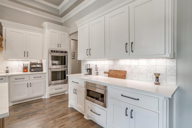 2161 Eagles Ridge Dr, Weatherford, TX 76087 - kitchen with crown molding, backsplash, light countertops, white cabinets, and appliances with stainless steel finishes