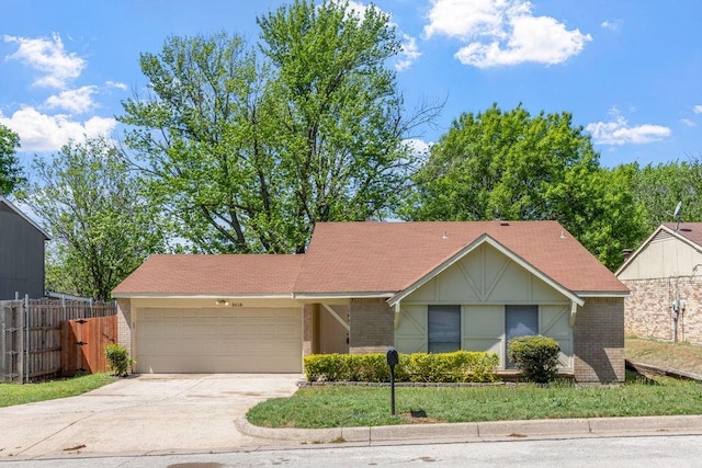 ranch-style home with an attached garage, fence, brick siding, and concrete driveway