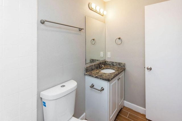 bathroom featuring wood finished floors, toilet, and vanity