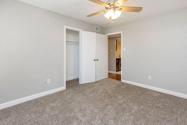 unfurnished bedroom featuring visible vents, a ceiling fan, a closet, baseboards, and carpet flooring