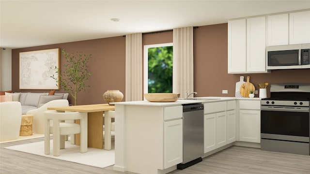 kitchen with a peninsula, a sink, stainless steel appliances, and light wood-style floors
