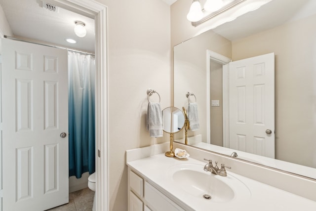 full bathroom with vanity, toilet, and tile patterned flooring