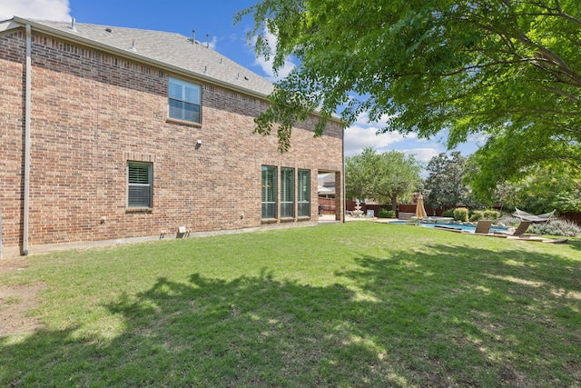 back of property featuring a lawn, brick siding, fence, and a patio area