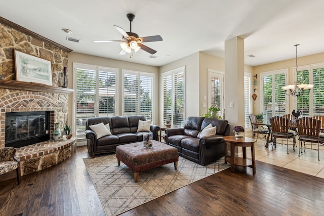 living room featuring ceiling fan with notable chandelier, light wood-type flooring, and a healthy amount of sunlight