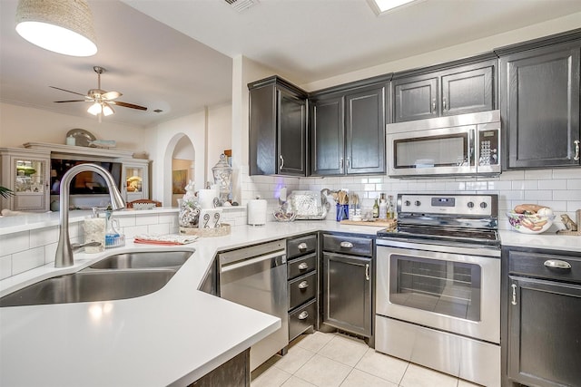 kitchen featuring decorative backsplash, appliances with stainless steel finishes, a sink, and light countertops