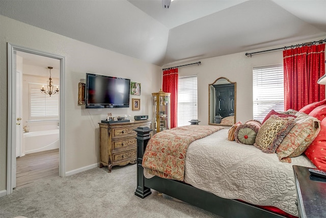 bedroom with vaulted ceiling, carpet floors, ensuite bath, baseboards, and a chandelier