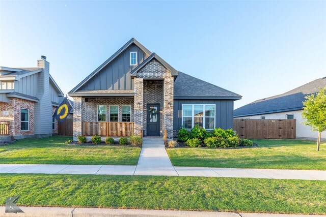 craftsman-style home featuring board and batten siding, brick siding, a porch, and a front lawn