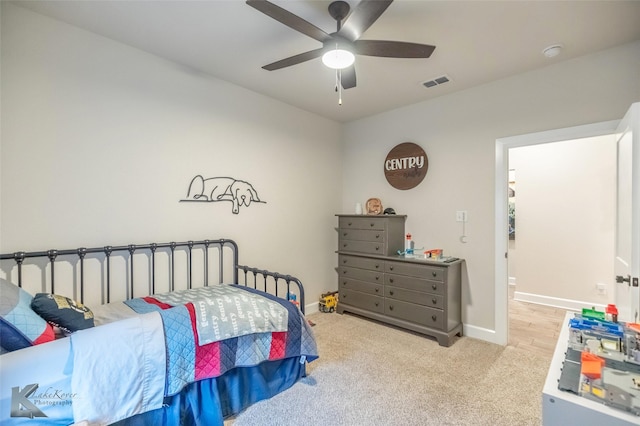 carpeted bedroom featuring baseboards, a ceiling fan, and visible vents