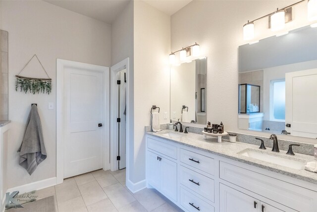 full bathroom featuring tile patterned floors, an enclosed shower, a sink, and double vanity