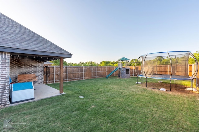 view of yard with a fenced backyard, a playground, a patio, and a trampoline
