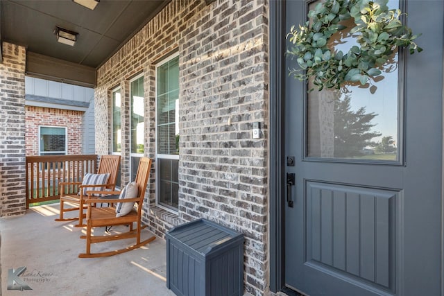 property entrance featuring brick siding and covered porch