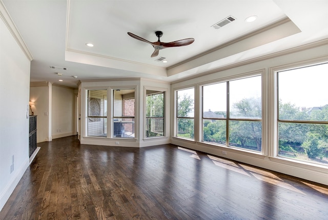 unfurnished living room with ornamental molding, a ceiling fan, and a tray ceiling