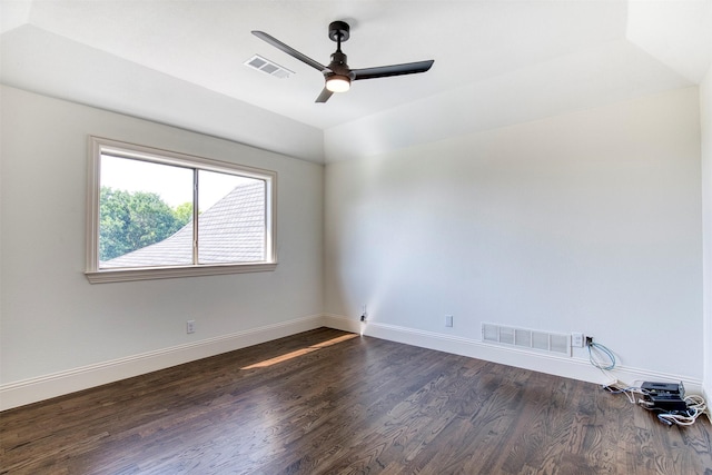 spare room with dark wood-style floors, visible vents, and a ceiling fan