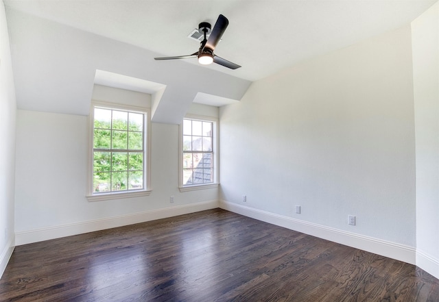 unfurnished room featuring lofted ceiling, dark wood-style flooring, ceiling fan, and baseboards