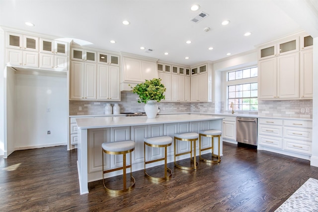 kitchen featuring light countertops, a center island, dishwasher, a sink, and visible vents