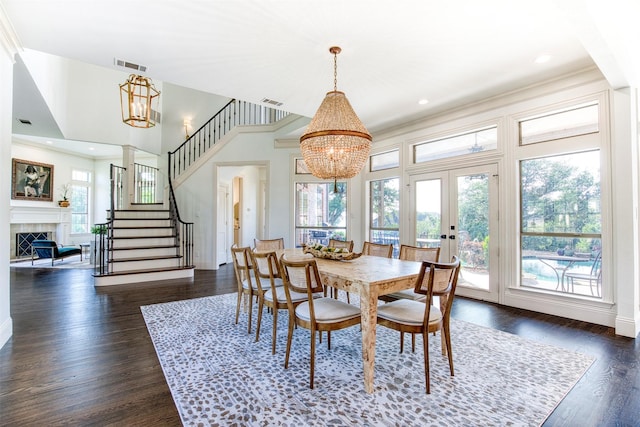 dining room featuring a chandelier, visible vents, a fireplace, french doors, and stairs