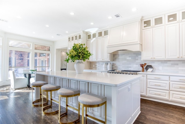 kitchen with a center island, backsplash, white cabinetry, and dark wood-type flooring