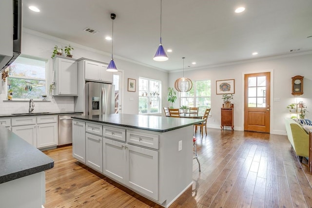 1833 Crested Ridge Rd, Fort Worth, TX 76008 - kitchen featuring a sink, dark countertops, visible vents, appliances with stainless steel finishes, and ornamental molding