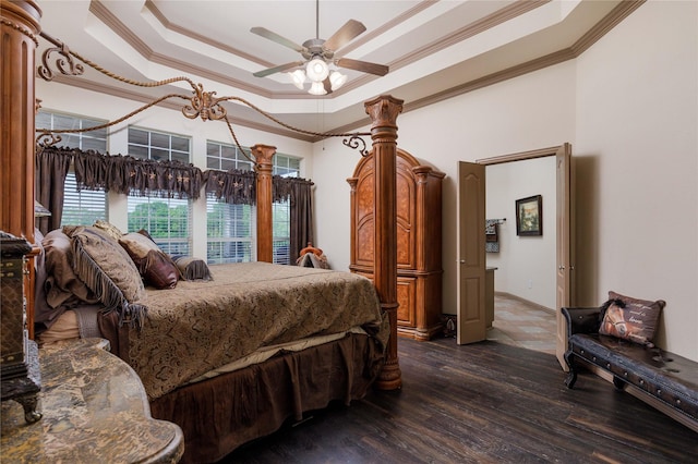 bedroom featuring a ceiling fan, dark wood-type flooring, a raised ceiling, and crown molding