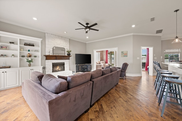 living area with ceiling fan, a wealth of natural light, light wood-style flooring, visible vents, and recessed lighting