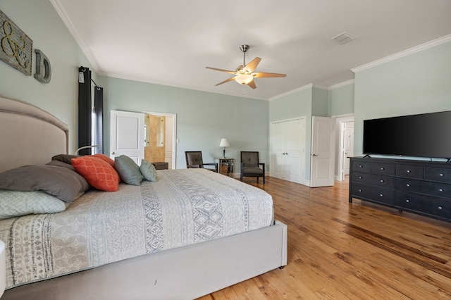 bedroom with a ceiling fan, crown molding, wood finished floors, a closet, and visible vents