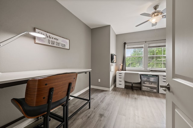 home office with a ceiling fan, baseboards, and light wood-style flooring