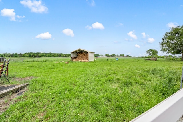 view of yard featuring a detached carport, a rural view, and fence
