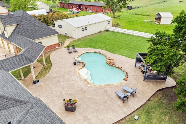 outdoor pool featuring fence, a lawn, and a patio