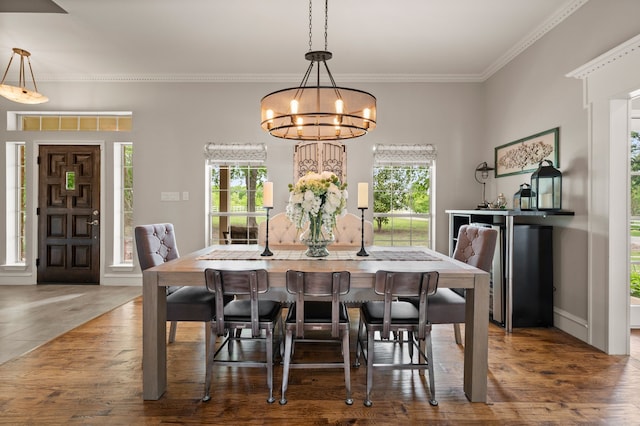 dining area with a chandelier, wood finished floors, crown molding, and baseboards