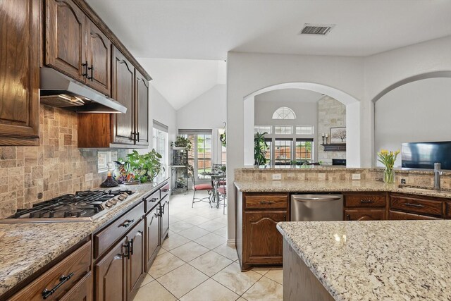 dining space featuring visible vents, high vaulted ceiling, ceiling fan with notable chandelier, a fireplace, and light tile patterned floors