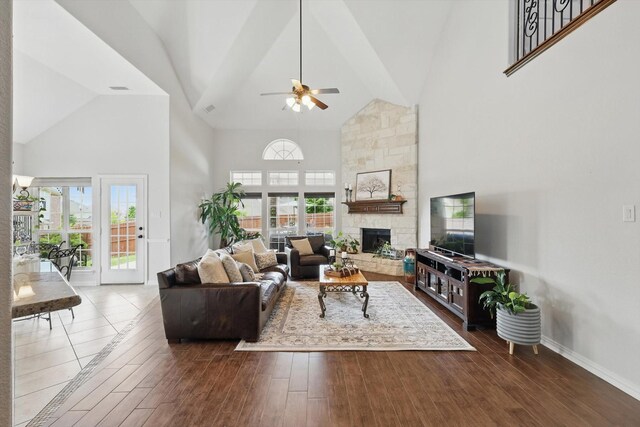 living area with dark wood-style floors, arched walkways, high vaulted ceiling, and ceiling fan with notable chandelier