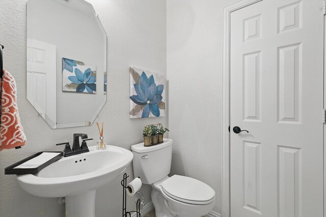 half bath with toilet and a sink