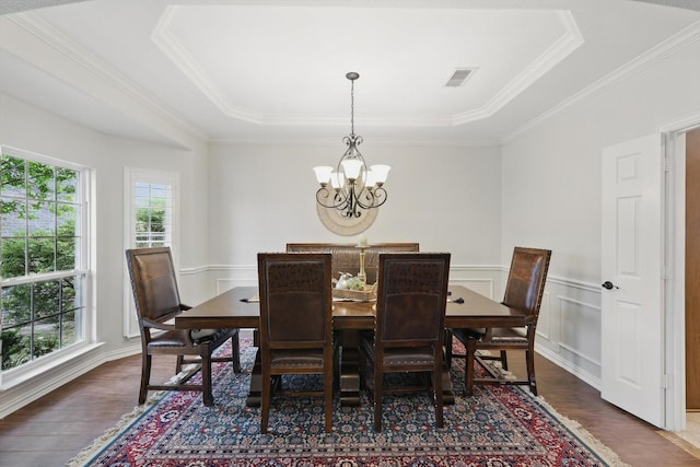 dining room featuring plenty of natural light, arched walkways, a notable chandelier, and a raised ceiling