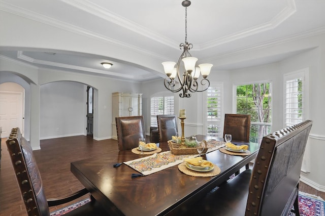 dining room featuring plenty of natural light, arched walkways, a notable chandelier, and a raised ceiling