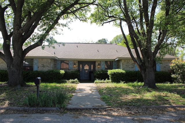 ranch-style home with brick siding and roof with shingles