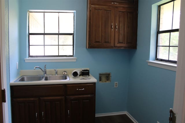 laundry room featuring cabinet space, washer hookup, baseboards, and a sink