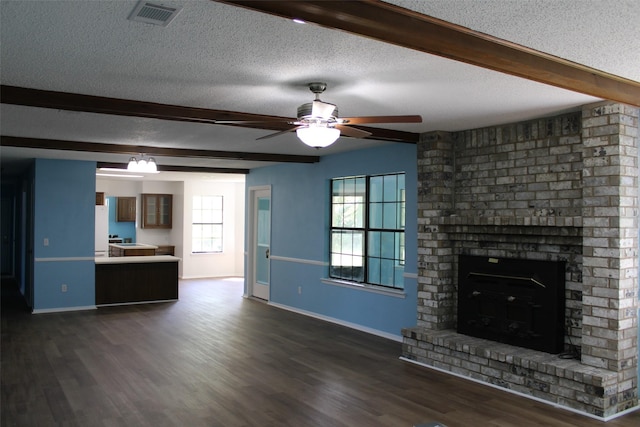 unfurnished living room with a textured ceiling, beam ceiling, ceiling fan, and visible vents