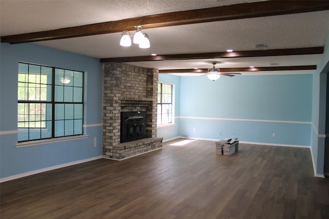 unfurnished living room with dark wood-type flooring, a textured ceiling, beam ceiling, and a ceiling fan