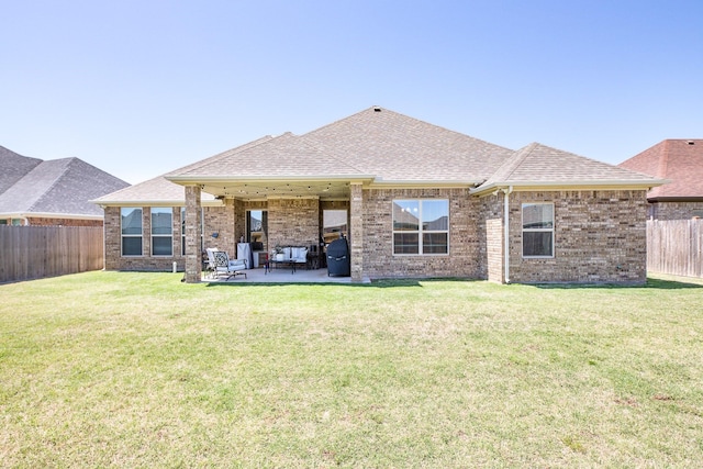 rear view of house featuring a fenced backyard, outdoor lounge area, brick siding, and a patio