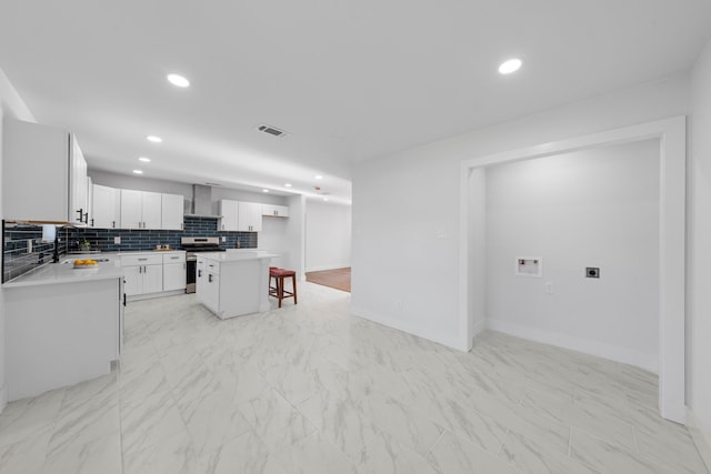 3712 Utah Ave, Dallas, TX 75216 - kitchen featuring stainless steel electric stove, a breakfast bar, wall chimney exhaust hood, baseboards, and visible vents
