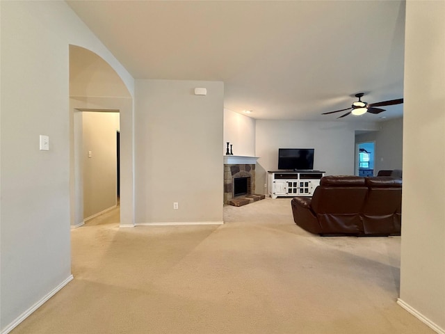 1131 Grimes Dr, Forney, TX 75126 - living room featuring carpet, a stone fireplace, ceiling fan, and arched walkways