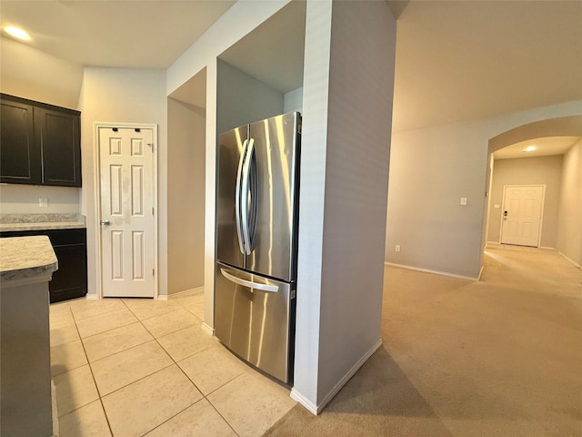 1131 Grimes Dr, Forney, TX 75126 - kitchen with freestanding refrigerator, arched walkways, light countertops, light tile patterned floors, and recessed lighting