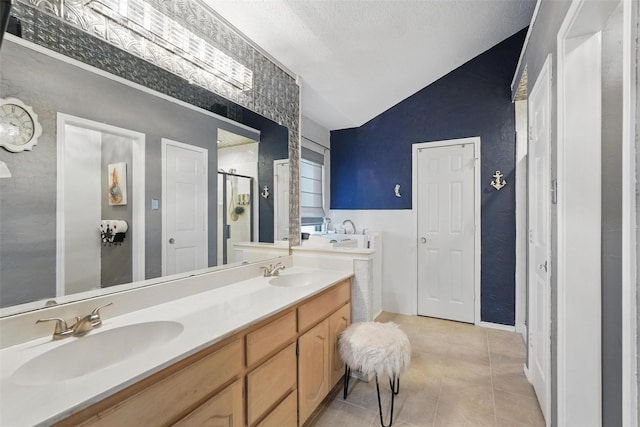 full bath featuring lofted ceiling, tile patterned flooring, a stall shower, and a sink