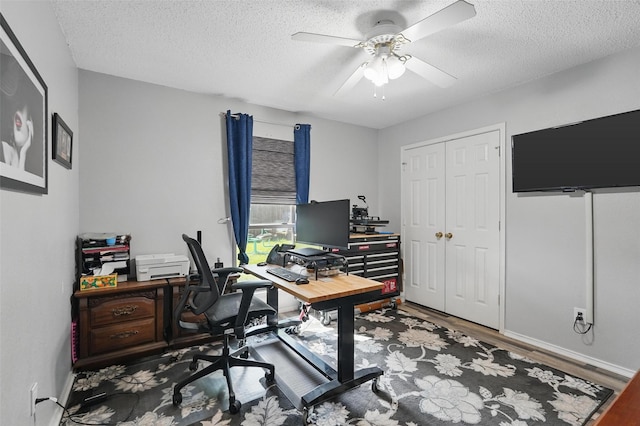 home office with baseboards, a ceiling fan, wood finished floors, and a textured ceiling