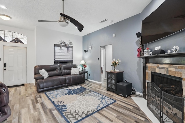 107 Princeton Cir, Forney, TX 75126 - living area with ceiling fan, wood finished floors, a fireplace, and a textured ceiling