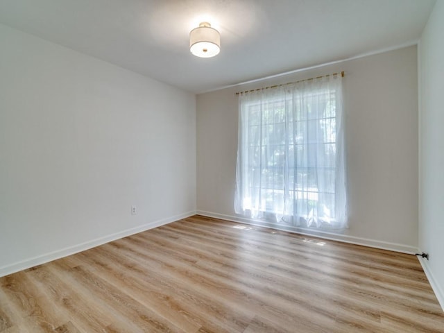 spare room with light wood finished floors and baseboards