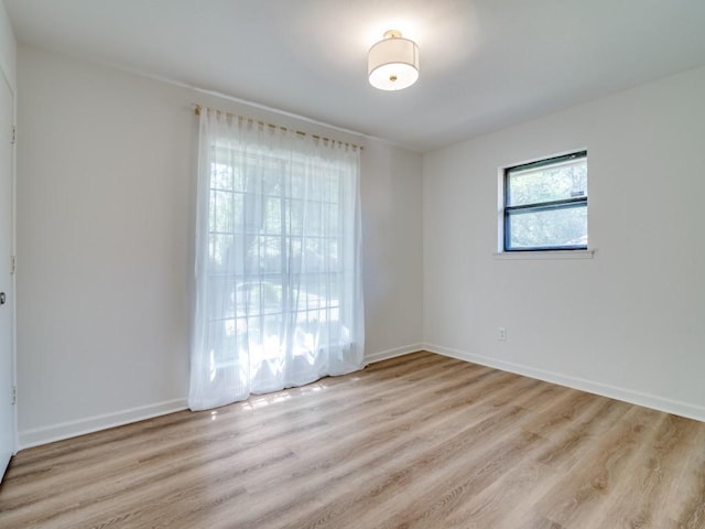 unfurnished room with baseboards and light wood-style floors